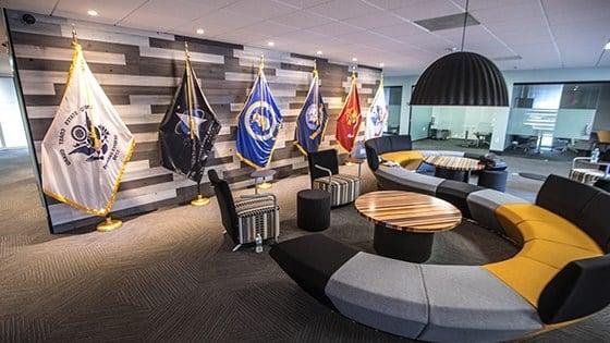 Full Sail军校学生成功中心的一张图片显示了一张大沙发, small meeting rooms, and flags representing each branch of the US Armed Services.